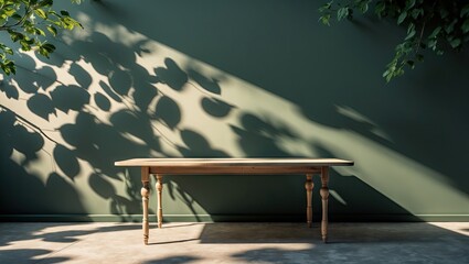 Poster - Minimalist wooden table positioned center stage against a muted green wall, featuring dramatic shadows from foliage casting intriguing patterns.