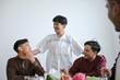 © Gatot - Asian Muslim Friends Enjoying Time Having Iftar Dinner Together at Home