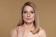 © New Africa - Portrait of beautiful woman with straight blonde hair on dark beige background