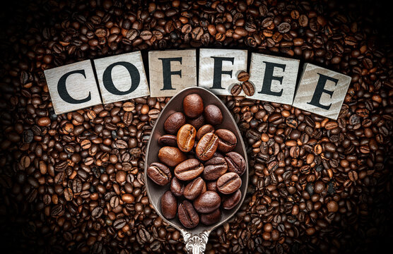 Extreme close-up and seen from directly above of the single word Coffee, made of wooden blocks on Background with roasted coffee beans and a metal spoon full of coffee beans. Generative Ai.