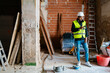 © Ezequiel Giménez/Stocksy - Construction manager using mobile phone during building renovation