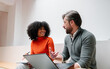 © VICTOR TORRES/Stocksy - Business professionals discussing ideas in modern office setting