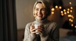 © Tati - Smiling woman holding cup, enjoying cozy indoor ambiance with warm lights