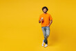 © ViDi Studio - Full body young smiling happy Indian man wear orange t-shirt casual clothes hold takeaway delivery craft paper brown cup coffee to go look camera isolated on plain yellow background Lifestyle concept