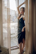 © Ирина Ваганова - beautiful girl in a black dress posing on the balcony