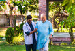 © StockImageFactory - Elderly Indian patient using a walking stick walks with a doctor in a hospital park, discussing health