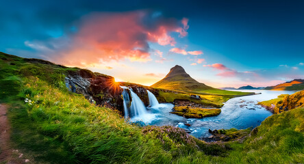Poster - Majestic mountain and waterfall landscape view during sunset. Colorful sky with clouds. Green grass and water stream in nature scenery.