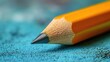 © Firadoaw - A close-up reveals a sharpened yellow pencil, its point honed to perfection, poised on a vibrant blue surface, ready to capture thoughts and ideas onto the page or canvas.