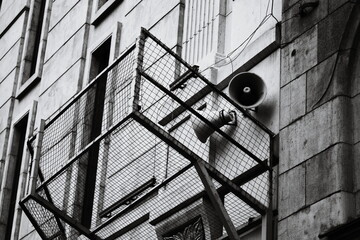 Poster - A black and white photo of a fire hydrant on the side of a building, great for urban or cityscape designs.