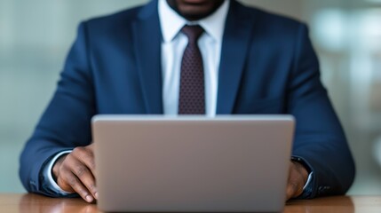 Poster - A professional man in a suit is working on a laptop, showcasing a modern business environment and focus on technology.