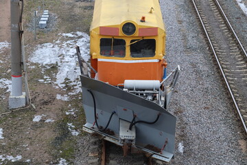 Aufkleber - A train with bright yellow and orange colors travels down train tracks.