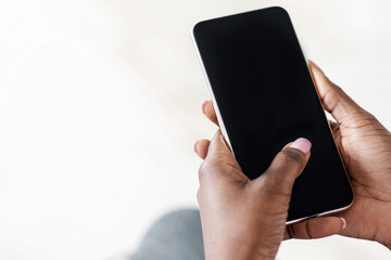 Fototapete - Unrecognizable Black Woman Using Smartphone With Blank Black Screen At Home, Checking New App Or Website, Browsing Internet, Spending Time With Gadget, Mockup Image With Empty Space, Closeup