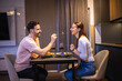 © Mediteraneo - Couple dining together in their apartment. They drink wine and feed each other.