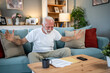 © Migma_Agency - Happy senior man celebrating good news reading documents at home