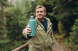 © mdyn - Happy blonde man in sport clothes having a halt after hiking. 30s Hiker drinking water from water bottle or hot drink from blue thermos. Travel, adventure, active lifestyle. High quality photo.