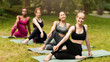 © Prostock-studio - Sporty young girls performing spinal twist during their morning yoga class at park, panorama