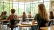 © Supranee - A classroom scene with students sitting at desks, facing forward, bathed in natural light from large windows.