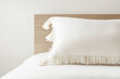 © Елена Сорокина - Elegant white pillow with fringe in a tranquil minimalist bedroom setting