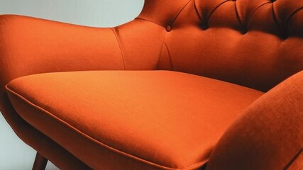 Poster - A vibrant orange chair features a modern design with tufted upholstery and elegant wooden legs. This stylish piece adds a pop of color to any room decor, blending comfort and aesthetics seamlessly.