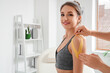 © Pixel-Shot - Male physiotherapist applying tape onto woman's shoulder in rehabilitation center