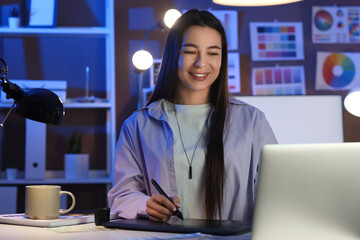 Poster - Female designer working with graphic tablet at office in evening