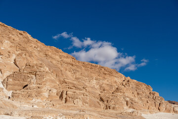 Poster - Clouds drift over the rugged cliffs of the Sinai desert in Egypt under a clear blue sky during daylight hours