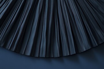 Poster - Elegant dark pleated fabric draping gracefully on a smooth surface in soft lighting