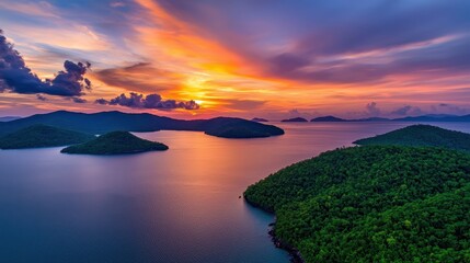 Poster - A breathtaking sunset over tranquil waters, with lush green islands silhouetted against a colorful sky, creating a serene and picturesque landscape.