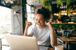 © Dusan Petkovic - Cheerful female entrepreneur sitting in cafe, looking at laptop and cheering for winning price.