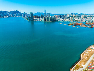 Aufkleber - Aerial panorama of Hong Kong, China, showcases a vibrant cityscape meeting the sea. Urban buildings and infrastructure stretch across the landscape under a clear sky.