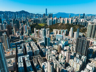 Aufkleber - Aerial panorama of Hong Kong, China, presents a dense cityscape with skyscrapers and mountains in the background under a clear sky.