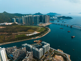 Poster - Aerial panorama shows Hong Kong city with high-rise buildings, bridges, and coastline. A wide view of the urban landscape and surrounding mountains.