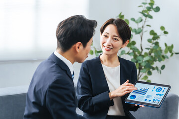 Poster - ロビーでタブレットを見ながら商談する男女ビジネスパーソンのグループ