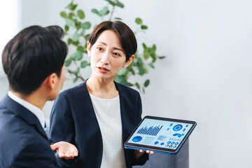 Aufkleber - ロビーでタブレットを見ながら商談する男女ビジネスパーソンのグループ