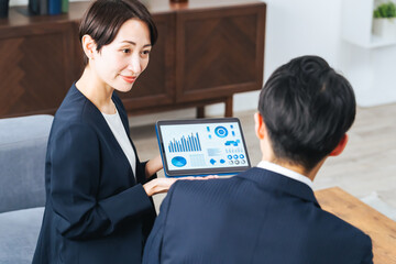 Aufkleber - ロビーでタブレットを見ながら商談する男女ビジネスパーソンのグループ