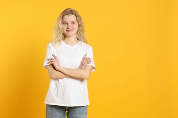 Wall Mural - young woman wearing blank white t-shirt on orange background. mockup for design