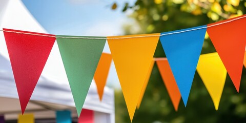 Poster - Colorful triangular flags hang in a festive atmosphere, adding vibrancy to an outdoor setting under a clear blue sky.