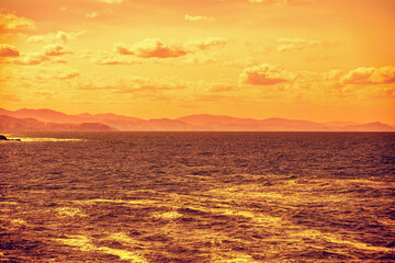 Wall Mural - cloudy sky over the sea at golden sunset. abstract nature background. donostia, san sebastian, basqu