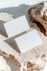 Poster - Two blank business cards rest on a textured stone surface, highlighted by sharp shadows that enhance the minimal aesthetic. The softly blurred background complements the contemporary look
