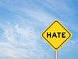 © bankrx - Yellow transportation sign with word hate on blue color sky background