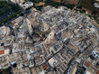 © AmazingAerialAgency - Aerial view of the beautiful Church of Saint George Martyr surrounded by historic medieval buildings and picturesque rooftops, Locorotondo, Bari, Italy.