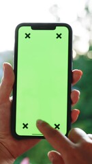 Vertical Format Video of Woman's hand holding mobile telephone with vertical green screen chroma key smartphone touch message display hand using mobile phone, browsing internet, watching content.