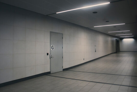 Empty concrete hallway with single locked door with ‘G’ on the front.