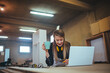 © Dragana Gordic - Woman Working in a Workshop Using Laptop and Drinking Coffee