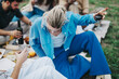 © qunica.com - A diverse group of friends shares a relaxing picnic on a cloudy day, enjoying wine and snacks in nature. The atmosphere is comfortable and inviting, perfect for bonding and relaxation.