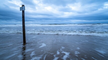 Aufkleber - Scenic coastal view featuring a weathered pole standing in the sand against a dramatic cloudy sky : Generative AI