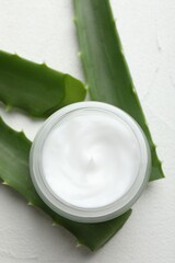 Wall Mural - cream and aloe leaves on white textured background, flat lay