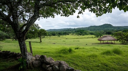 Poster - Lush Green Meadow Under a Majestic Tree with a Thatched Roof Hut in the Background : Generative AI