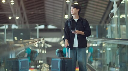 Happy asian man with backpack checking flight in phone on escalator in airport terminal, People concentrating typing digital device for travel in transportation, Concept of travel