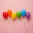© Alex Pios - Close-up of rainbow balloons and glitter on a pink background, festive LGBTQ+ celebration decor.